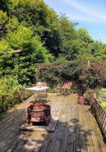 a table sitting on a wooden deck with trees at The Boat Inn in Monmouth