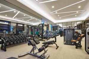 a gym with a lot of treadmills and machines at Wanda Vista Hotel Urumqi in Ürümqi