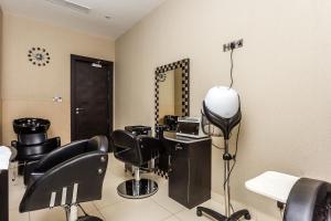 a hair salon with black chairs and a mirror at Royal Canaan Nairobi Hotel in Nairobi +103 photos