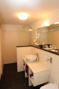 a bathroom with a white sink and a mirror at Designhotel Im Südfeld in Kamen