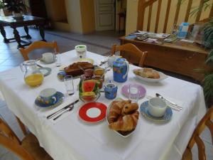 une table avec un tissu de table blanc et de la nourriture dans l'établissement LA FERME DE ROUFFIGNAC, à Blanzac