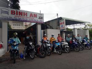 un grupo de personas en motocicletas estacionadas frente a una gasolinera en Binh An Backpacker Guesthouse, en Ho Coc