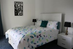 a bedroom with a white bed with a white headboard at 130 At The Waves in Cowes