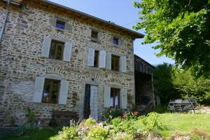 an old stone house with red and white windows at Le 46 in Saint-Sauver-la-Sagne