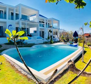 a villa with a swimming pool in front of a house at Villa Argia Nusa Penida in Nusa Penida