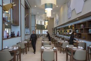 a restaurant with people walking through a dining room at Riu Plaza España in Madrid