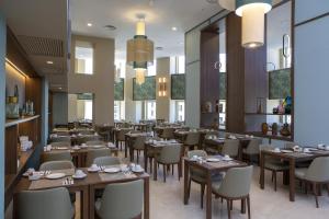a restaurant with tables and chairs in a room at Riu Plaza España in Madrid