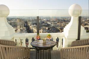 a table on a balcony with a view of a city at Riu Plaza España in Madrid