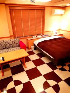 a bedroom with a bed and a checkered floor at HOTEL CIMA Ⅱ ( Adult Only ) in Kotohira