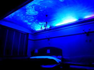 a blue room with a bed and an aquarium on the ceiling at HOTEL CIMA Ⅱ ( Adult Only ) in Kotohira