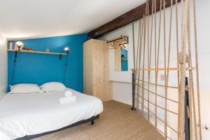 ボルドーにあるDuplex lumineux au coeur de Bordeaux avec Parkingの青い壁のベッドルーム1室(ベッド1台付)