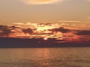 a sunset over the ocean with the sun setting at 1 Emplacement Parfait ! 150m de la mer et de la rue Piétonne in Dieppe +4 photos