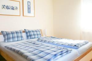 a bed with blue and white pillows on it at Ferienwohnung Quick in Winterberg