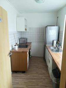 una pequeña cocina con fregadero y nevera. en Apartment/Ferienwohnung im ruhigen Calden in der nähe von Kassel, en Calden
