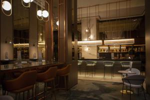 a bar in a restaurant with bar stools at Riu Plaza España in Madrid