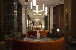 a lobby with a table and chairs and a chandelier at Riu Plaza España in Madrid