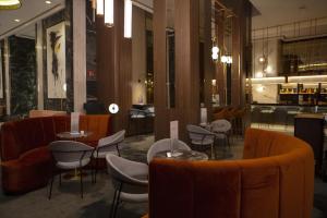 a restaurant with tables and chairs in a lobby at Riu Plaza España in Madrid