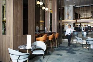a man walking through a restaurant with a bar at Riu Plaza España in Madrid