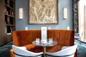 a dining room with a table and chairs and a painting at Riu Plaza España in Madrid