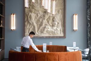 a man standing behind a couch in a room at Riu Plaza España in Madrid