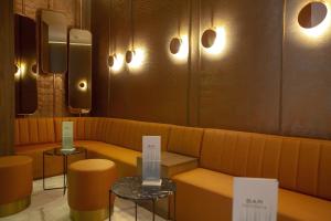 a room with a couch and two tables and lights at Riu Plaza España in Madrid
