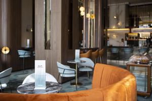a restaurant with a couch and chairs and a table at Riu Plaza España in Madrid