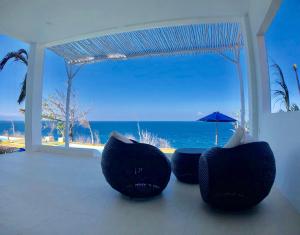 una camera con due sedie e vista sull'oceano di Villa Argia Nusa Penida a Nusa Penida