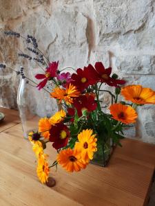 eine Vase voller bunter Blumen auf dem Tisch in der Unterkunft Chambre d Hote 1873 in Frasne