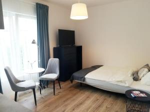 Un dormitorio con una cama y una mesa y sillas. en Apartamenty Maki, en Gdansk