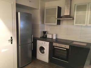 eine Küche mit einem Kühlschrank und einer Waschmaschine in der Unterkunft Nice appartment between Orly airport and Paris in Bagneux