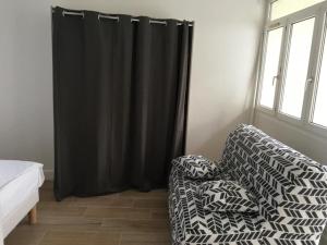 ein Wohnzimmer mit einer Couch und einem schwarzen Vorhang in der Unterkunft Nice appartment between Orly airport and Paris in Bagneux + 1 Foto