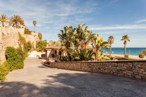 einen Gehweg neben einer Steinmauer am Meer in der Unterkunft Cala Cristal by Pierre & Vacances Premium in Miami Platja