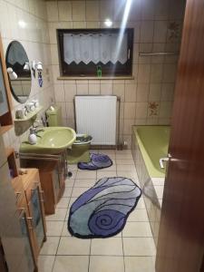 a bathroom with a sink and a tub and a toilet at Ferienwohnung Preuß in Martinlamitz