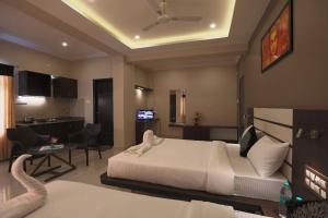 een hotelkamer met een bed en een keuken bij Aadya Elite in Mysore