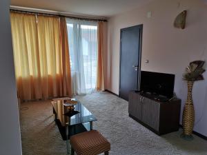 sala de estar con TV, mesa y sillas en Комплекс Антик, en Troyan