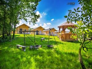 un patio con columpios, cenador y casas en Ośrodek Bajka en Zator