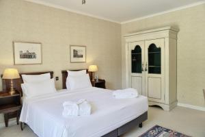 a bedroom with a large white bed with towels on it at Le Manoir de Gressy in Gressy