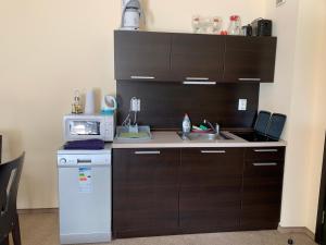 a small kitchen with a sink and a microwave at Apartment with terrace in Spa Complex in Burgas City