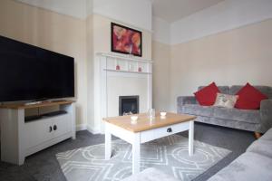 a living room with a tv and a fireplace at Handbridge House in Chester