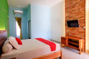 Un pat sau paturi într-o cameră la RedDoorz near Taman Makam Pahlawan Tatura