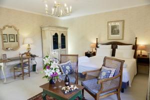 a bedroom with a bed and chairs and a table at Le Manoir de Gressy in Gressy