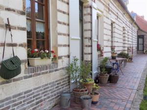 un patio avec des plantes en pot sur le côté d'un bâtiment dans l'établissement Gîte des Demoiselles, à Beauval