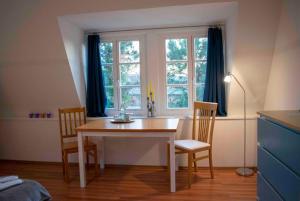 Una mesa de comedor con dos sillas y una ventana. en Sülfmeister Haus, en Lüneburg 43 fotos más