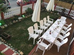 a white table with white chairs and an umbrella at Adriani Inn in Paralia Katerinis