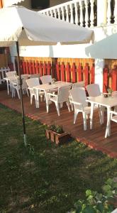 a row of white tables and chairs on a deck at Adriani Inn in Paralia Katerinis