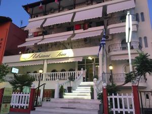 a white building with stairs in front of it at Adriani Inn in Paralia Katerinis