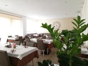 a restaurant with tables and chairs and a clock on the wall at Hotel Paganella in Molveno