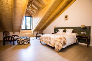 1 dormitorio con 1 cama grande y techo de madera en The Rock Suites & Spa en Congosto