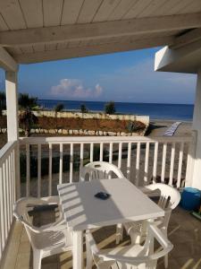 a white table and chairs on a balcony with the beach at Campeggio Lao in Scalea