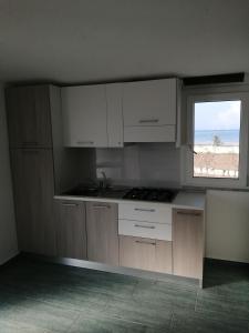 an empty kitchen with white cabinets and a window at Campeggio Lao in Scalea +27 photos